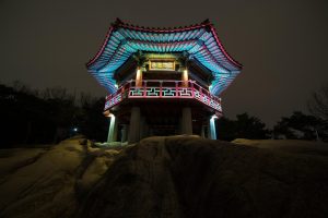 桔子视频热播韩剧剧照，男女主角在首尔夜景背景下对视，现代都市爱情氛围浓郁